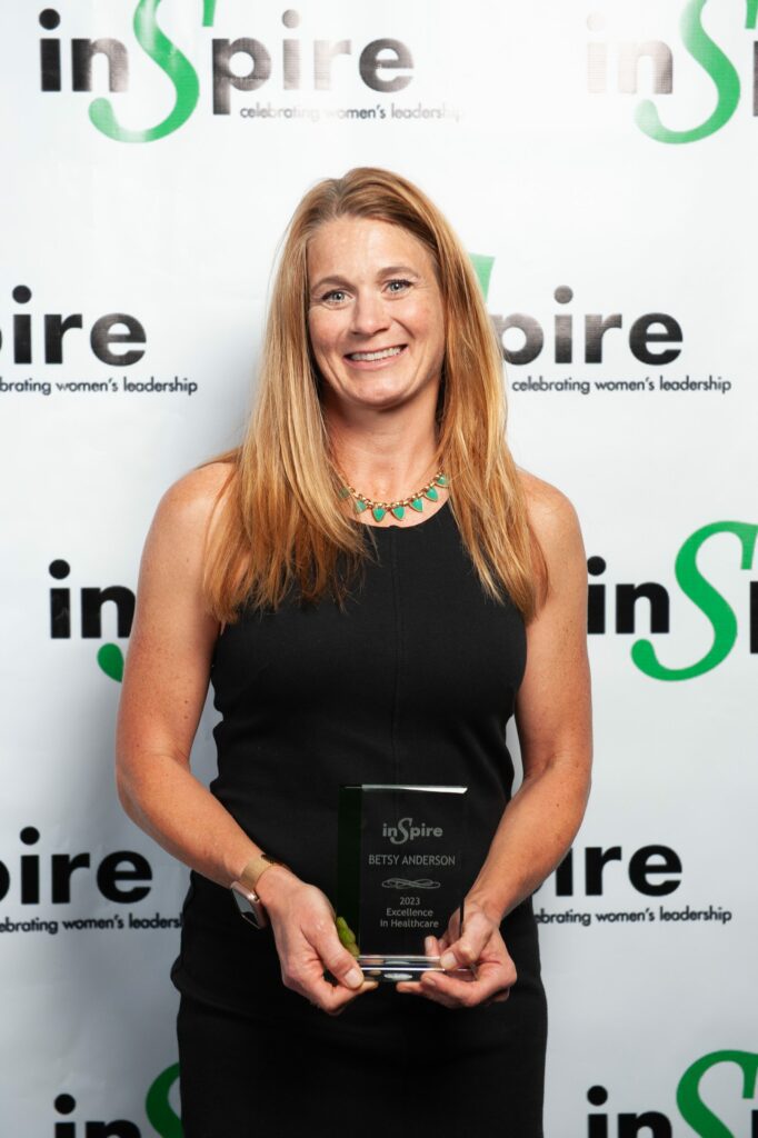 Betsy Anderson holding the Inspire Women Award for Excellence in Healthcare.